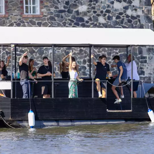 Group of people drinking beer on a beer boat in Prague.