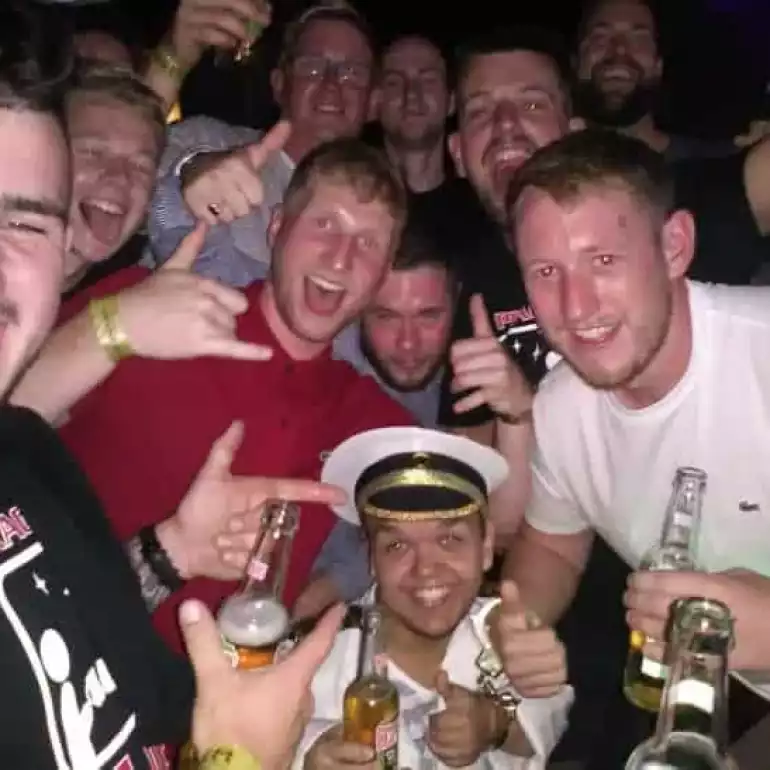 Group of guys on a bachelor party in Budapest posing during a bar craw.