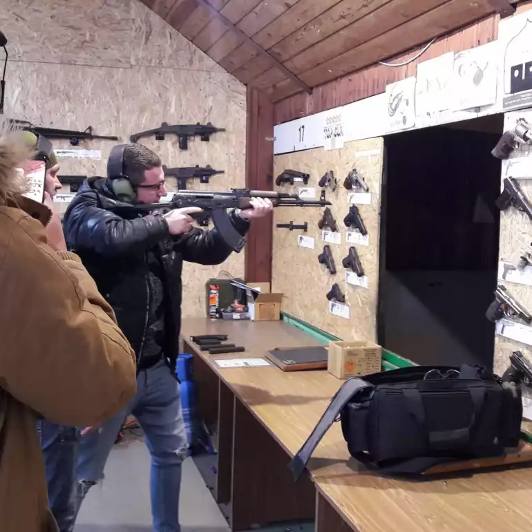 Group of guys shooting AK47 at a gun range in Prague.