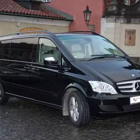 Black Mercedes Benz van parked outside of a building.
