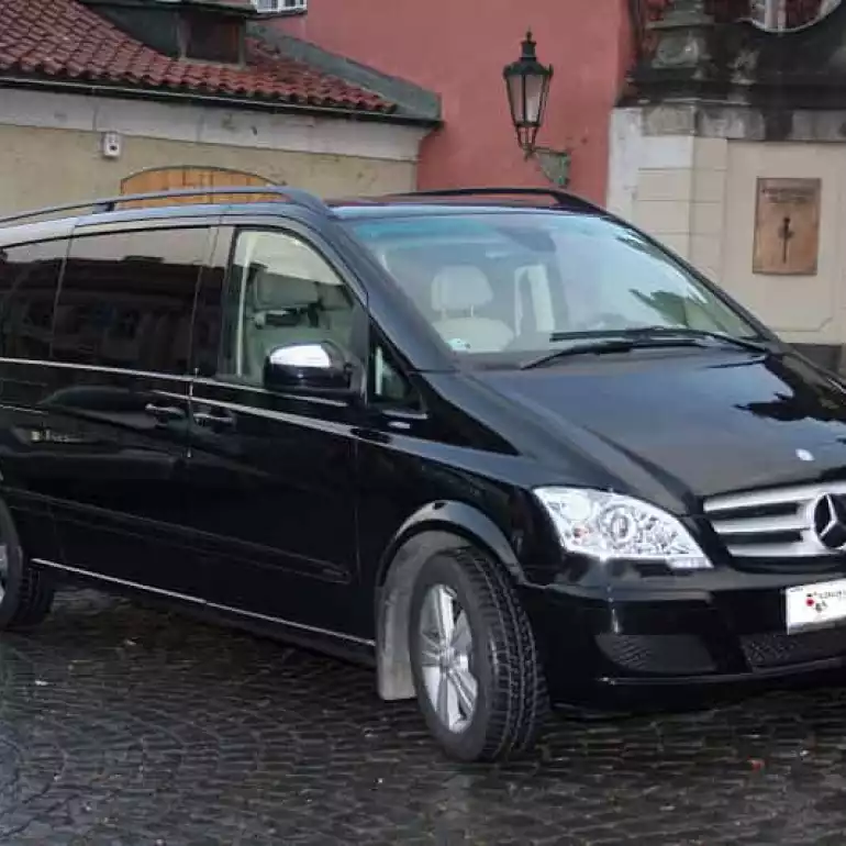 Black Mercedes Benz van parked outside of a building.