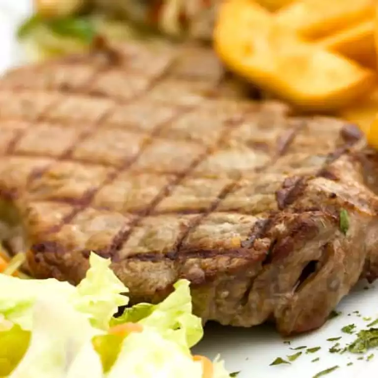 Well grilled beef steak with salad and fries.