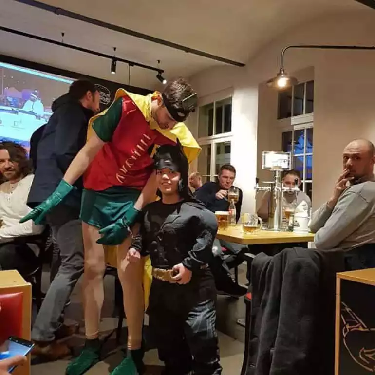 Group hired a dwarf entertainer dressed as Batman to pose with their friend dressed as Robin.
